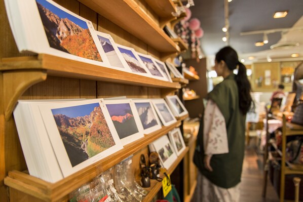 Una exposición de fotografías enmarcadas sobre estantes de madera en una tienda.
