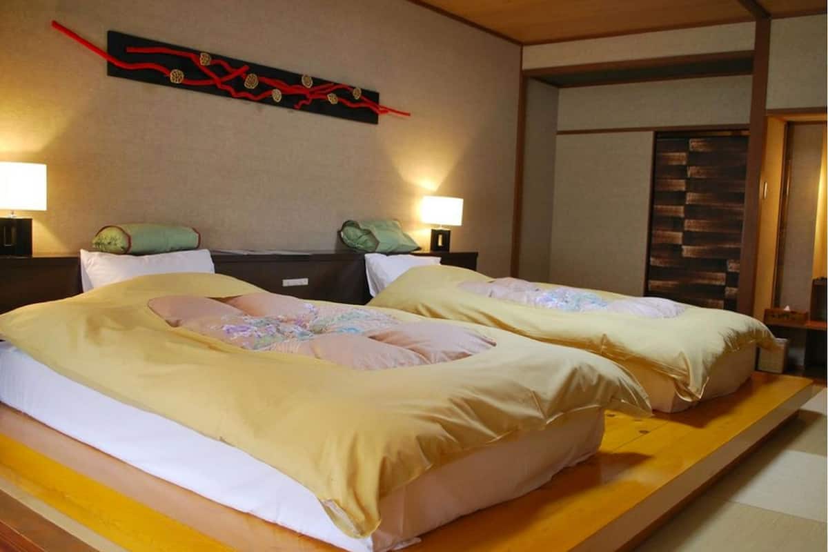 Habitación de hotel con dos camas, una plataforma de madera y un adorno en la pared.