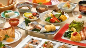 Variedad de platos en una mesa, como sushi, sashimi y otras especialidades asiáticas.