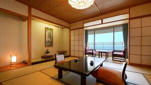 A traditional Japanese room with tatami flooring, a low table, cushions, and sliding doors. - Hotel Grand Mer Sankaiso (Ajigasawa)