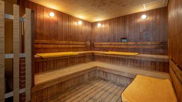 Een sauna met houten banken, een houten vloer en plafondverlichting.