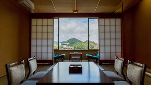 A room with a large window, a wooden table, and four chairs. - New Hakkeien (Izunokuni)