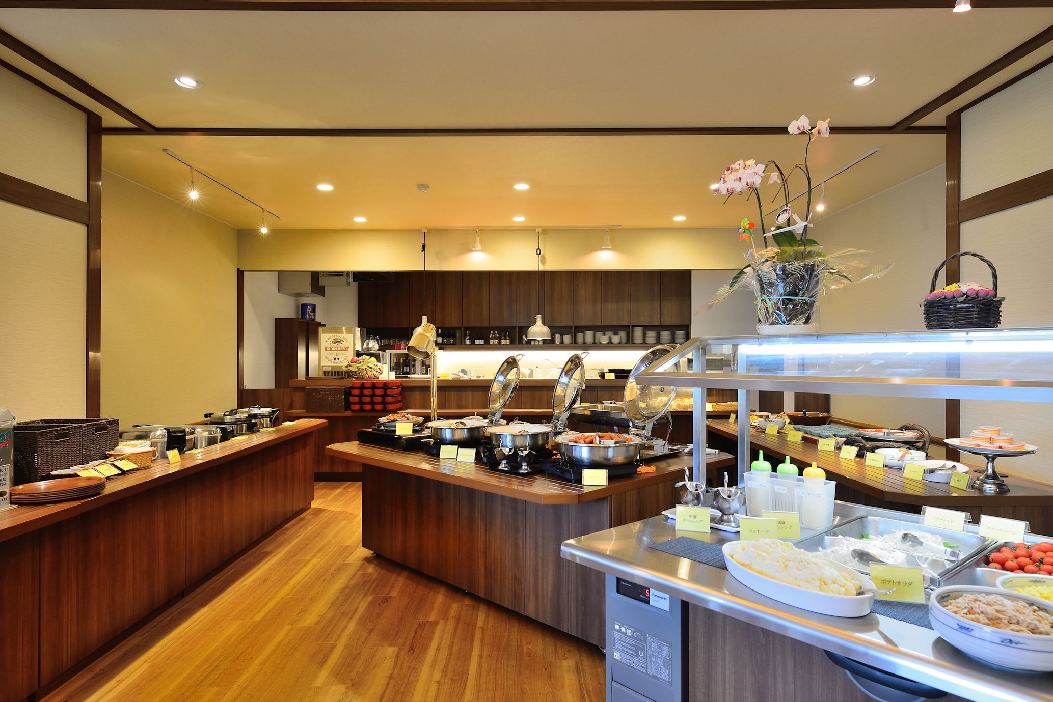 A buffet area with various food stations and a wooden counter.