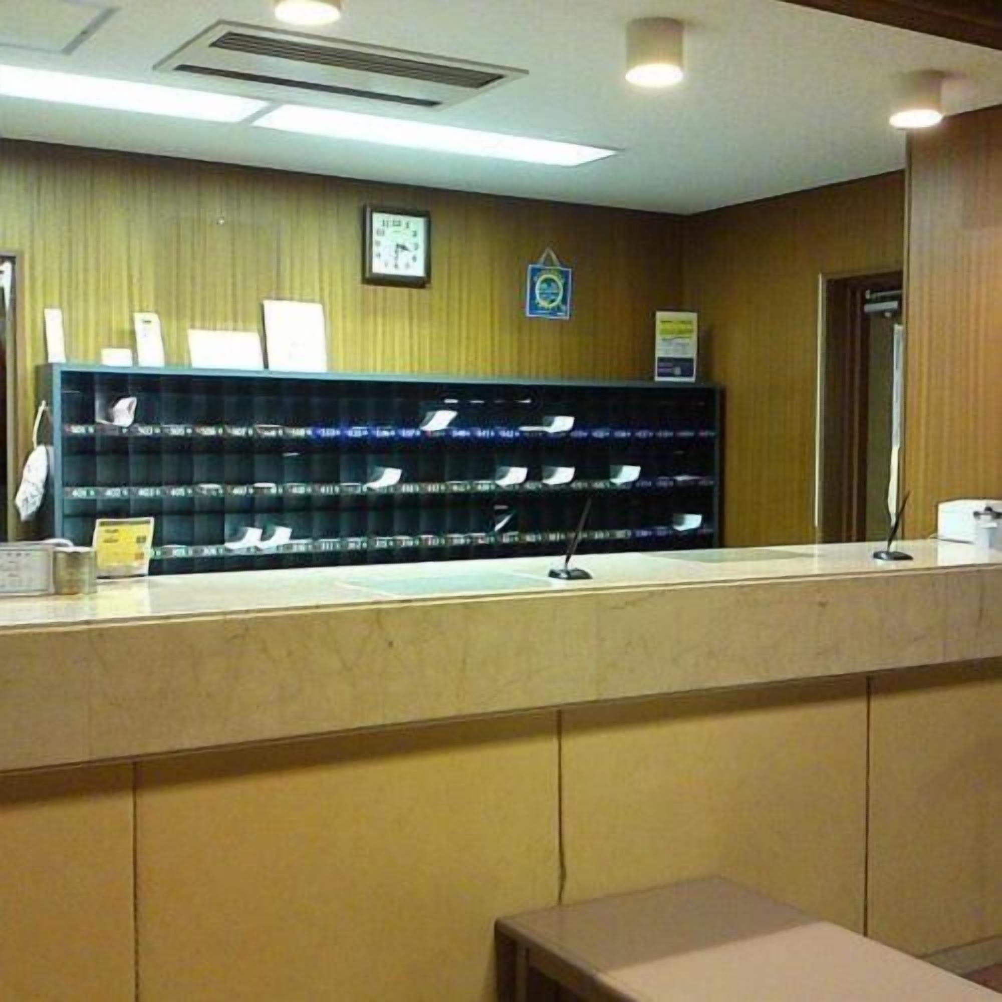 A reception desk with a counter, a wall-mounted clock, and a framed certificate or award.