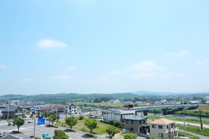 Vista de un pueblo con un puente sobre un río, edificios y una carretera con vehículos.