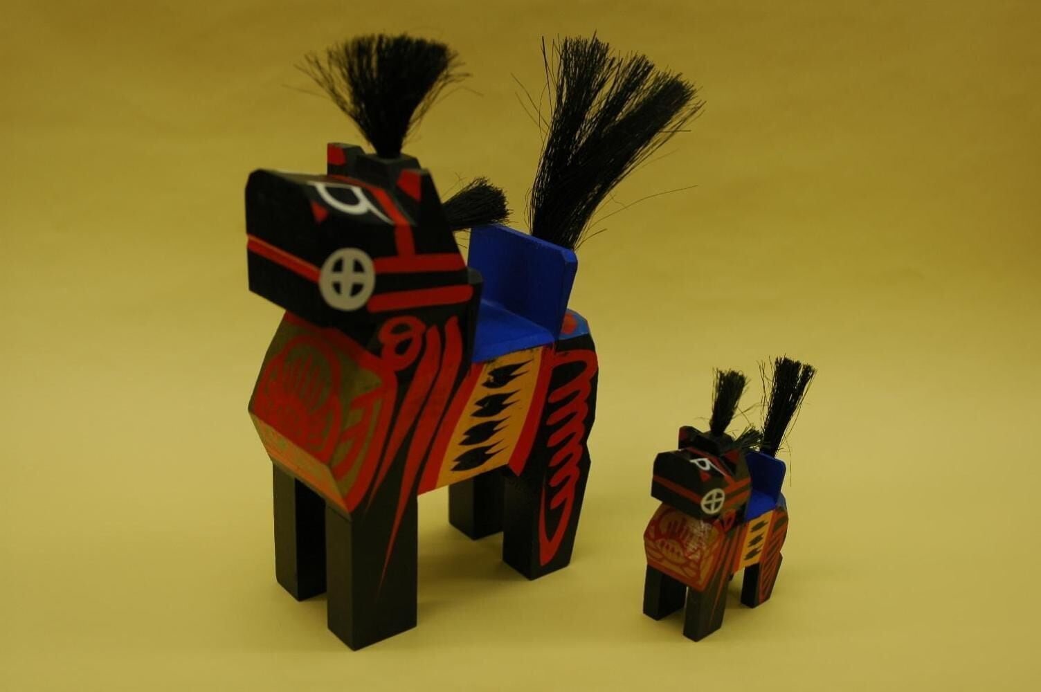 Tres pequeñas esculturas coloridas de animales con diseños y patrones característicos.