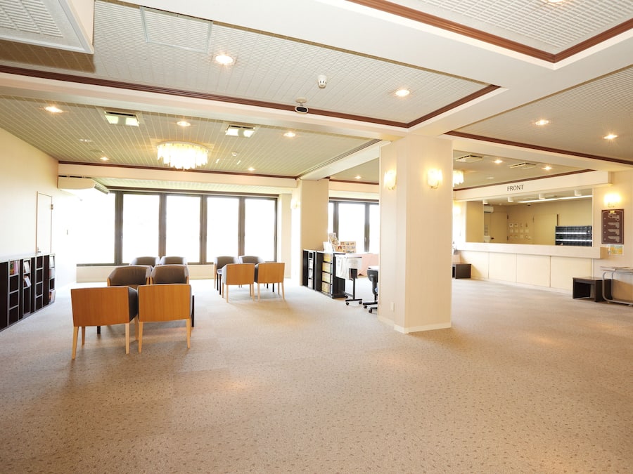 A spacious room with a high ceiling, large windows, and a reception desk labeled "FRONT".