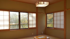 Egy hagyományos japán szoba, tatami szőnyeggel, toló shoji-ajtókkal és egy faasztallal.