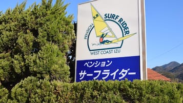 A sign for Surf Rider with Japanese text and a sailboat graphic.