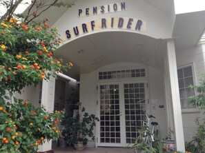 Entrada de un edificio con un letrero que dice "Pension Surfrider".