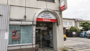 A hotel entrance with a sign for 'Hotel Suehiro Matsuyama' and 'Tabist'.