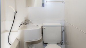 A bathroom with a toilet, sink, and shower.