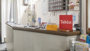 A reception desk with a red sign labeled "Tabist".