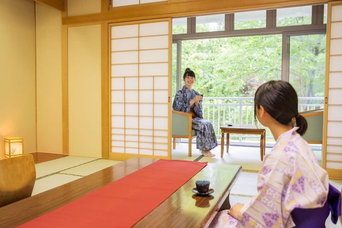 Habitació japonesa tradicional amb tatami, una taula baixa i una porta corredissa.