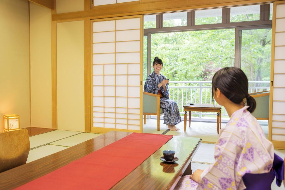 A traditional Japanese room with tatami flooring, a low table, and a sliding door.