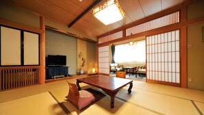 A traditional Japanese room with tatami flooring, a low wooden table, and sliding doors. - Nisshinkan (Kusatsu)