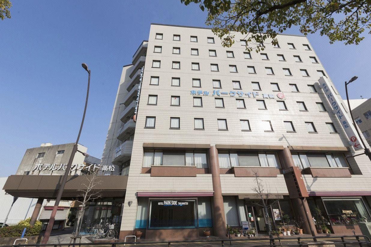 Ein mehrstöckiges Hotel mit einem Schild, auf dem 'Hotel Park Side Takamatsu' steht.