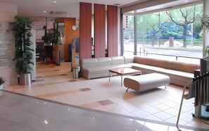 A modern lobby with a sofa, coffee table, and potted plants. - Business Hotel Park Side Takamatsu (Takamatsu)
