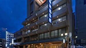 A multi-story hotel with a prominent sign, multiple balconies, and a covered entrance area. - Subaruyado Yoshino (Tokushima)
