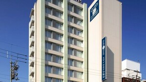 Een modern hotelgebouw met meerdere verdiepingen en een opvallend bord dat aangeeft dat het een hotel is.