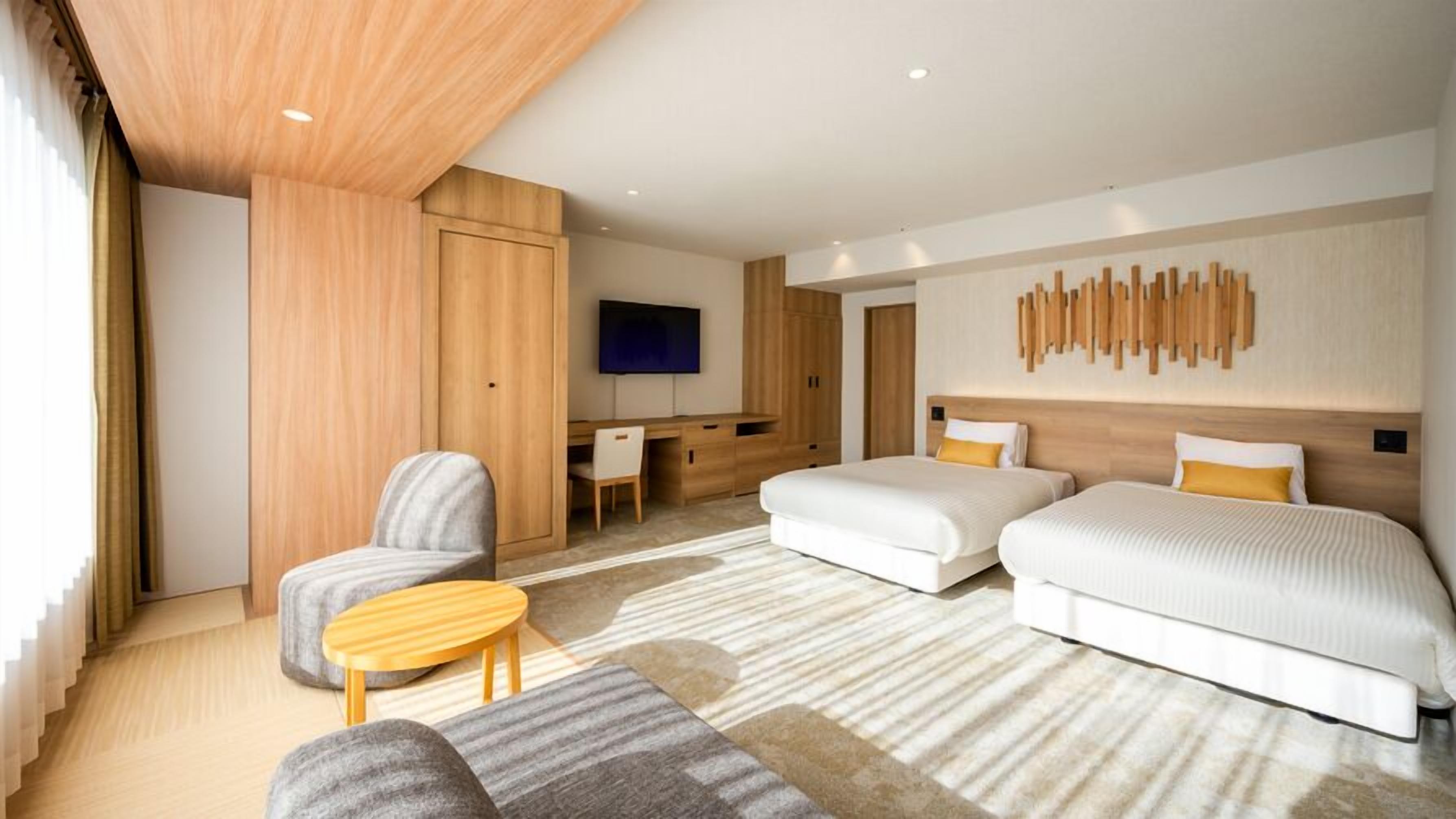 Een moderne hotelkamer met een bed, bureau, stoel en televisie.