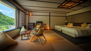 A modern hotel room with tatami flooring, a bed, a desk, and a view of a lush green landscape. - Yu No Mori Hotel Shidotaira (Hanamaki)