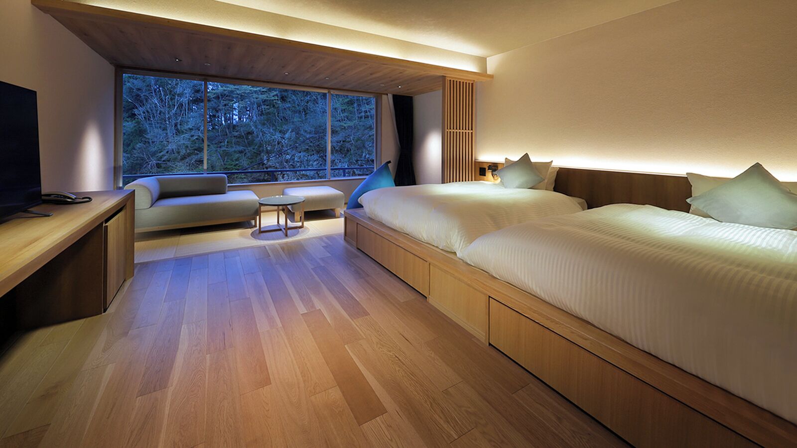 Une chambre moderne avec une grande fenêtre, un canapé, un lit et un bureau.