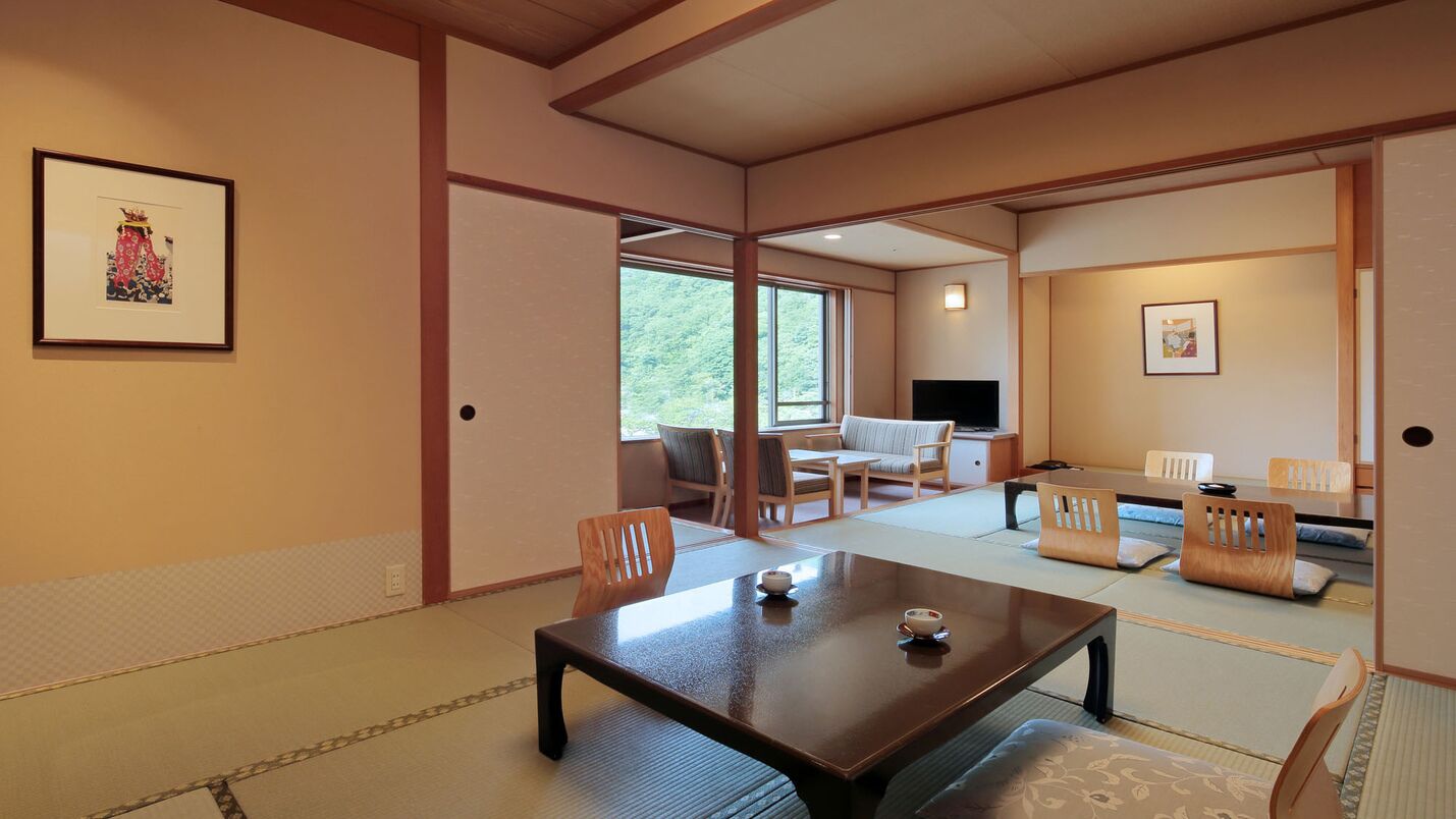 Une pièce de style japonais traditionnel, avec un sol recouvert de tatamis, une petite table basse et un téléviseur en arrière-plan.