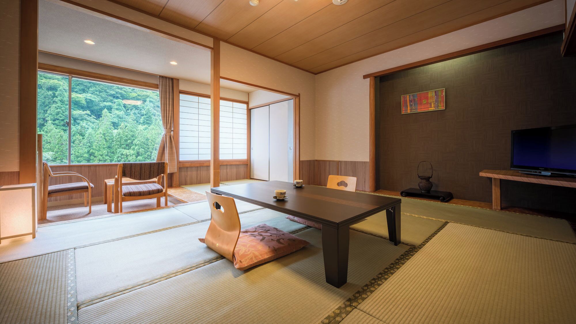 Een traditionele Japanse kamer met tatami vloerbedekking, een lage tafel en schuifdeuren.