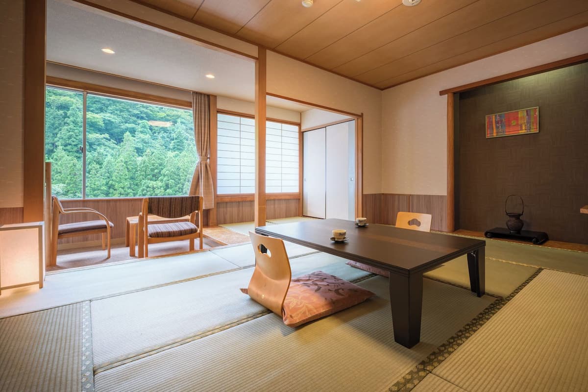 Ett traditionellt japanskt rum med tatamimattor på golvet, ett lågt bord och skjutdörrar.