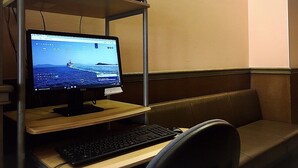 Una computadora sobre un escritorio de madera con monitor, teclado y ratón.