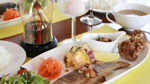 A dining table with a variety of dishes including a whole fish, rice, salad, and a dessert. - Guest House Hilltop (Nagano)