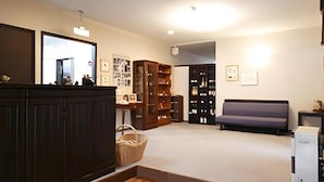 A spacious room with a large wooden cabinet, a sofa, and a collection of framed pictures on the wall.