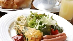 A plate with a salad, a slice of quiche, sausages, and ketchup. - Guest House Hilltop (Nagano)