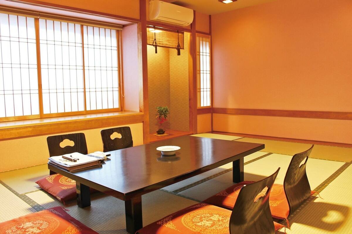 Une pièce de style japonais traditionnel, avec un sol recouvert de tatamis, une table basse et des paravents coulissants.