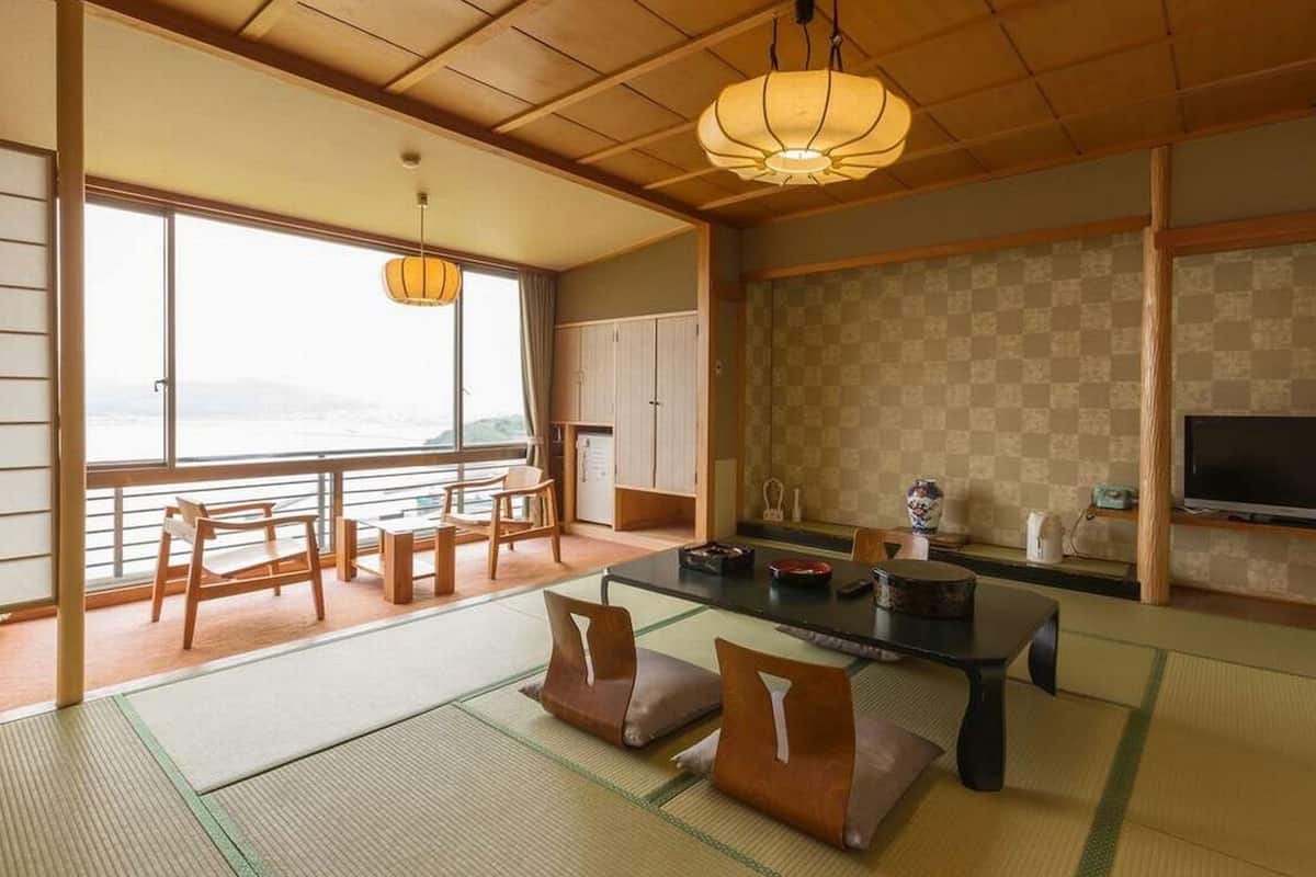 Ein traditioneller japanischer Raum mit Tatami-Böden, einem niedrigen Tisch und Meerblick.