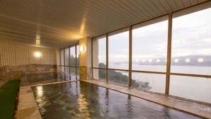 A spa area with a hot tub, large windows, and a view of a body of water. - Wano Resort Hazu (Gamagori)