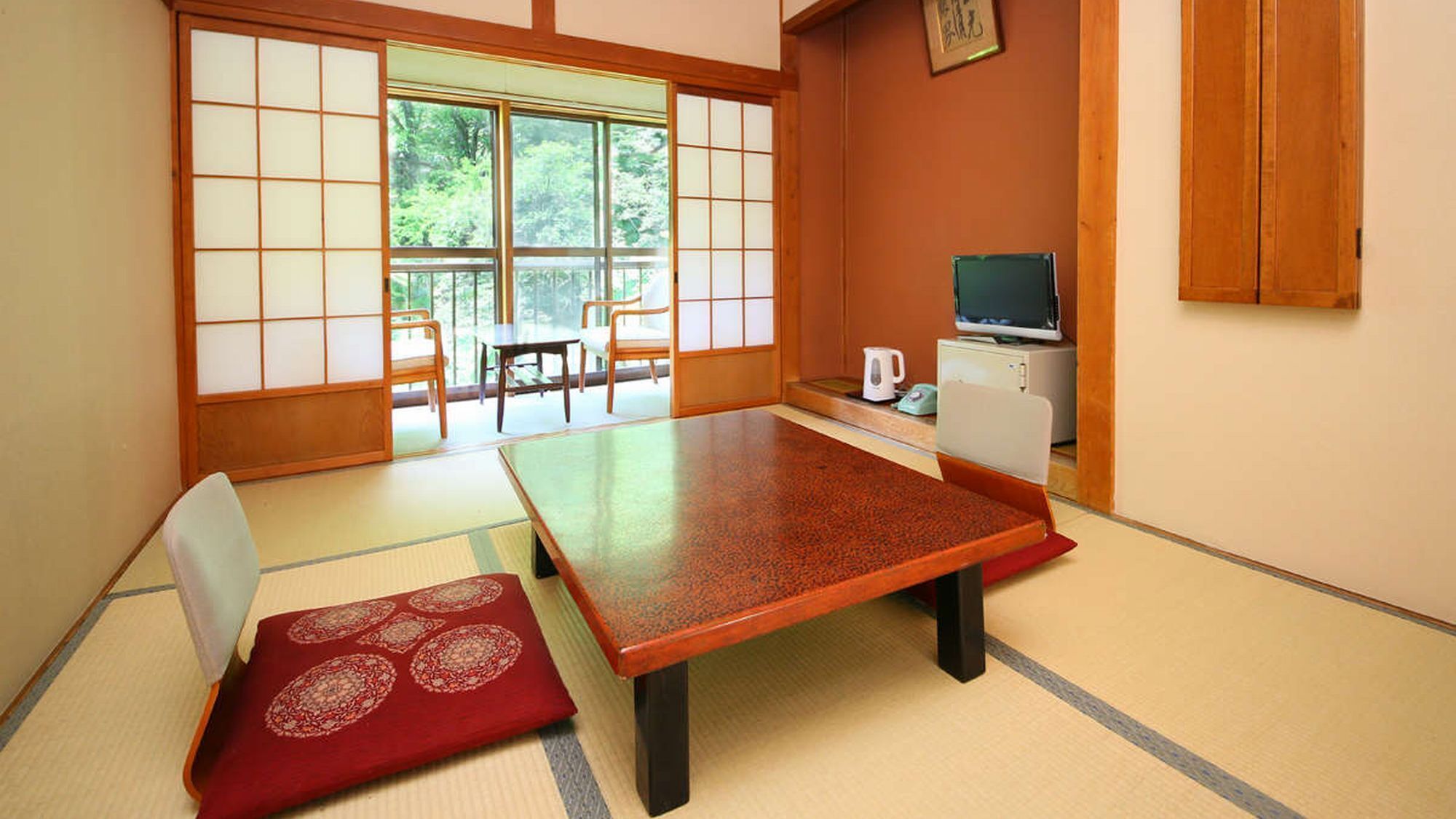 Une pièce de style japonais traditionnel, avec un sol recouvert de tatamis, une table basse et des portes coulissantes.
