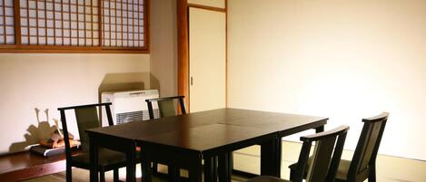 A traditional Japanese-style room with tatami flooring, a low table, and shoji screens.