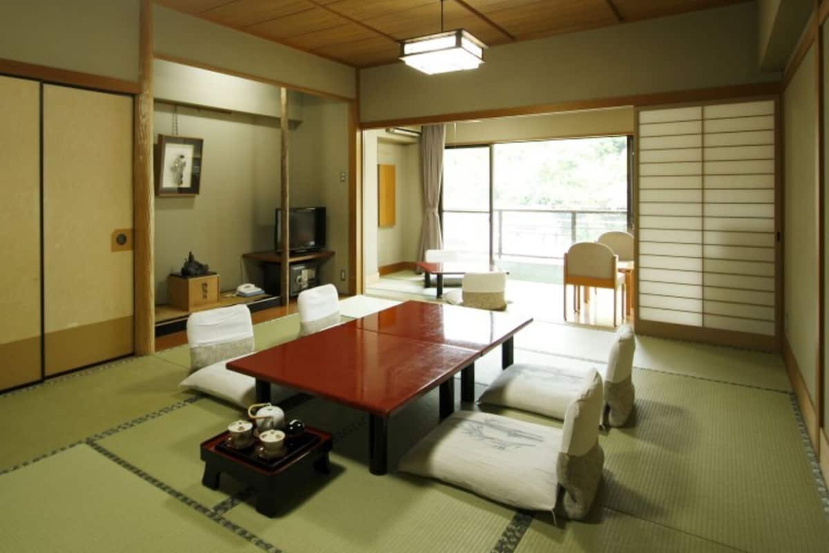 Perinteinen japanilainen huone, jossa on tatamimatto, matala pöytä ja liukuovi.