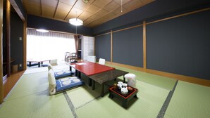 Ett traditionellt japanskt rum med tatamimattor på golvet, ett lågt träbord och en sittplats med tatamimattor.