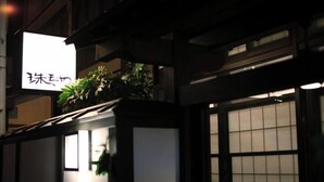 A traditional building with a signboard, wooden structure, and large windows. - Yutagawa Onsen Kuhe Ryokan Tamaya (Tsuruoka)