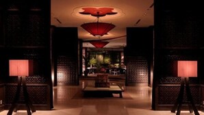 A dimly lit interior with traditional decor, a central table, and a patterned wall. - Konaya Hotel (Kofu)