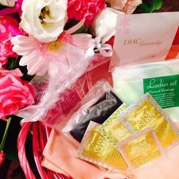 Un ramo de flores, una tarjeta y botellas de aceite de oliva.