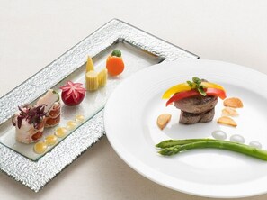 Un plato con carne, verduras y un adorno.