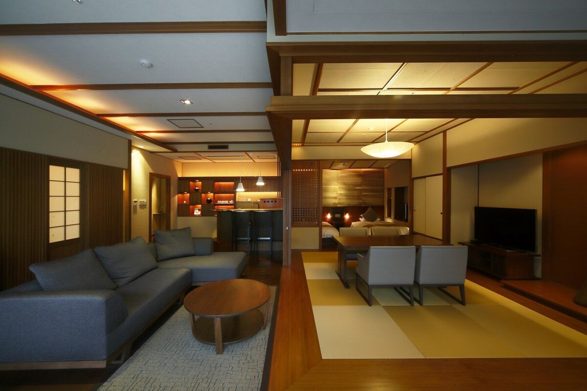 A modern living room with a sofa, coffee table, and TV.