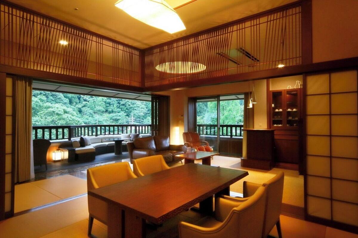 A traditional Japanese-style room with tatami flooring, a low table, and a sofa.