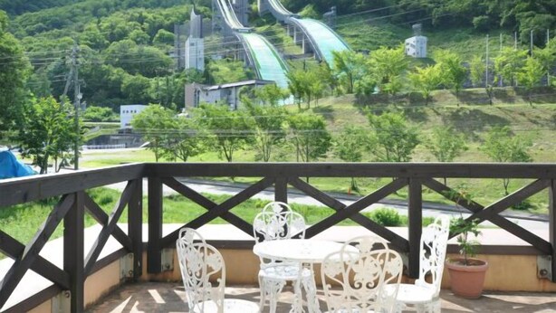 A view of a water slide park with a chair and table set on a balcony.