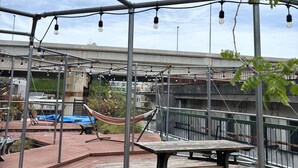 Eine Dachterrasse mit Hängematte, Tisch und Bank.