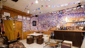 Ein Zimmer mit einer Holzvertäfelung voller Fotos, einem Tisch und einer Couch.
